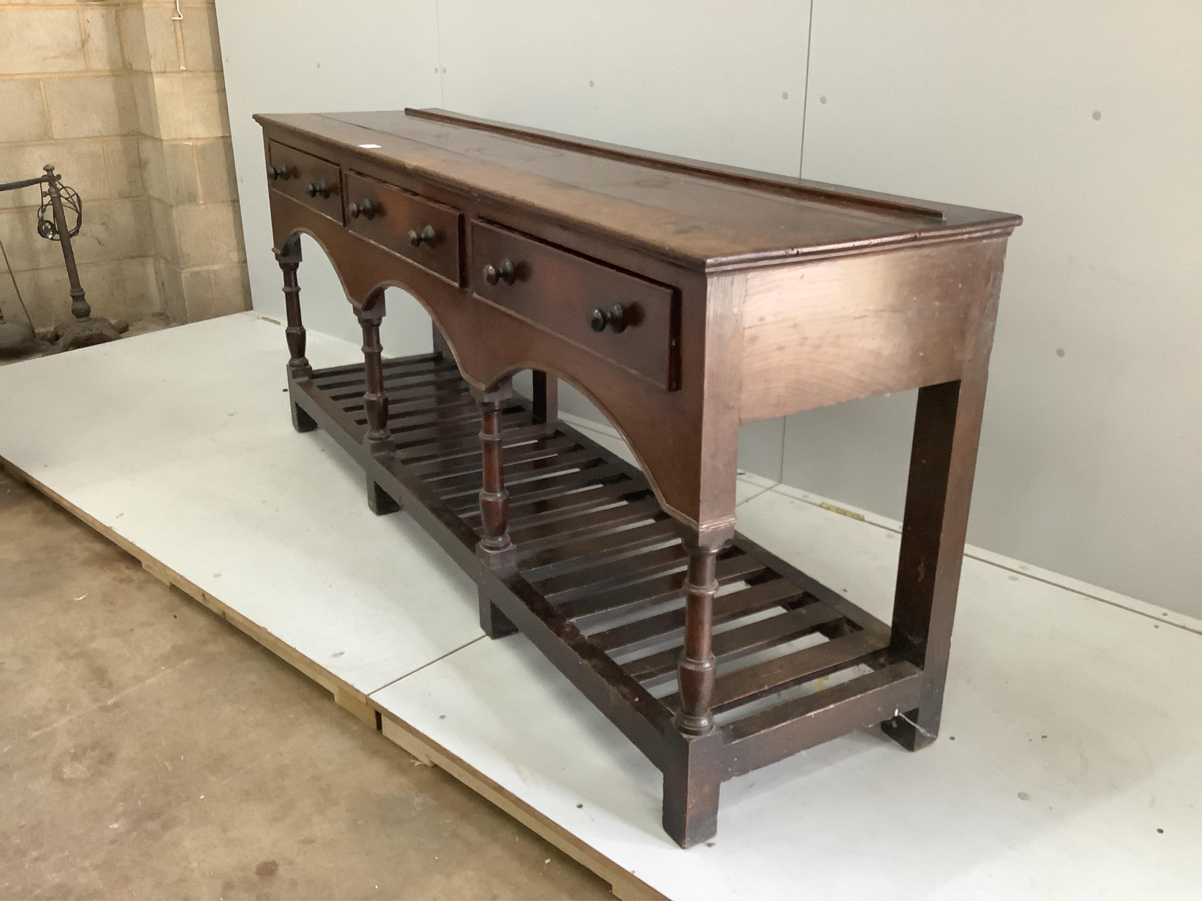 A mid 18th century oak potboard low dresser, fitted three drawers with bronze knob handles, width 194cm, depth 49cm, height 82cm. Condition - fair